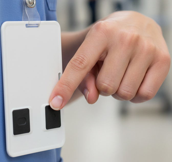 Caregiver pressing a button on a wearable staff duress badge